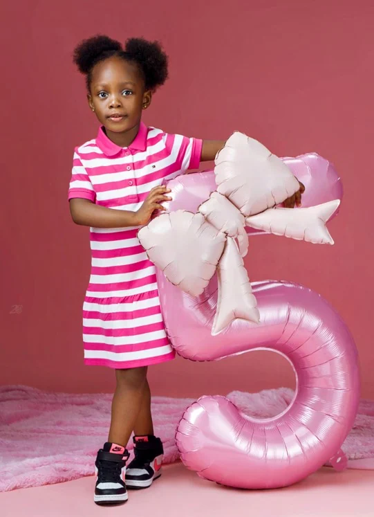 Fifth birthday portrait with a pink balloon